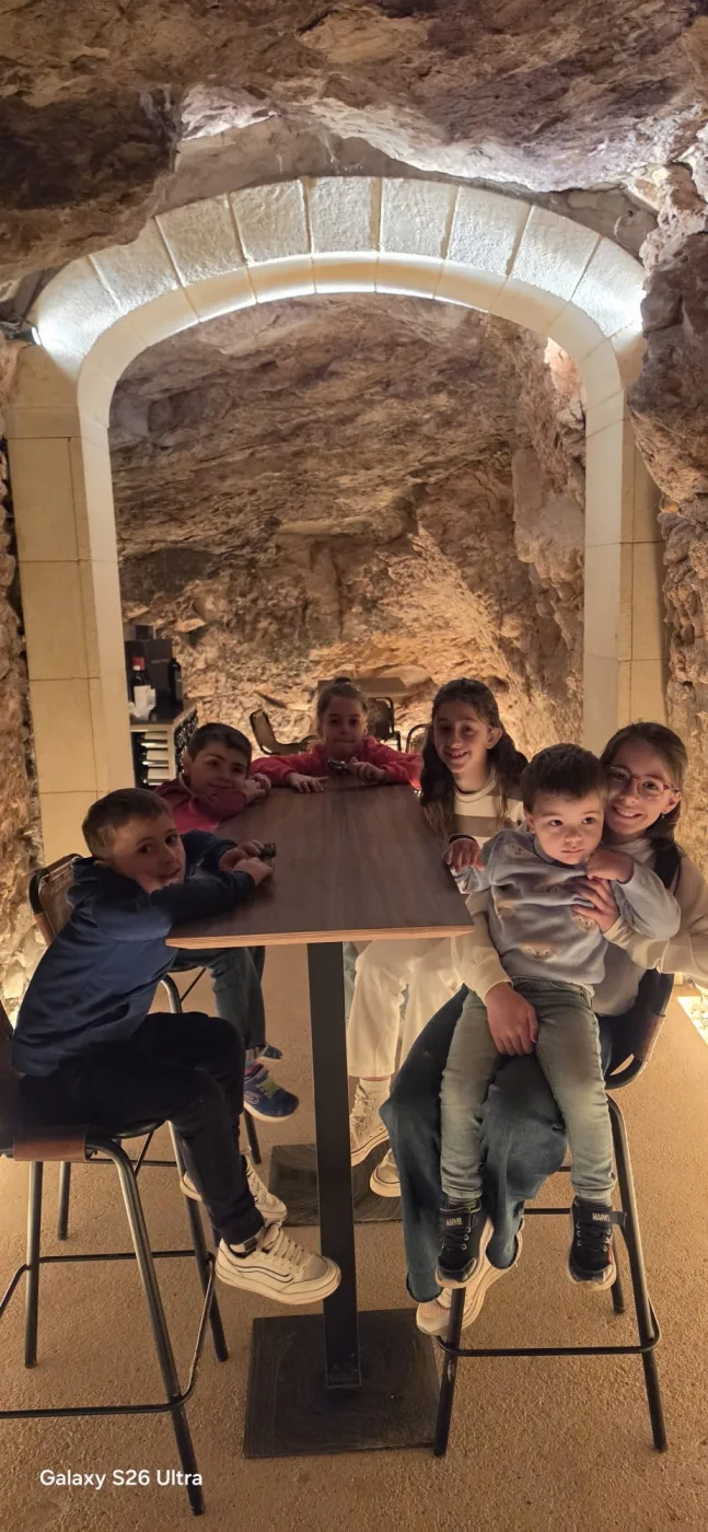 Niños y familia reunidos alrededor de la mesa del calado.